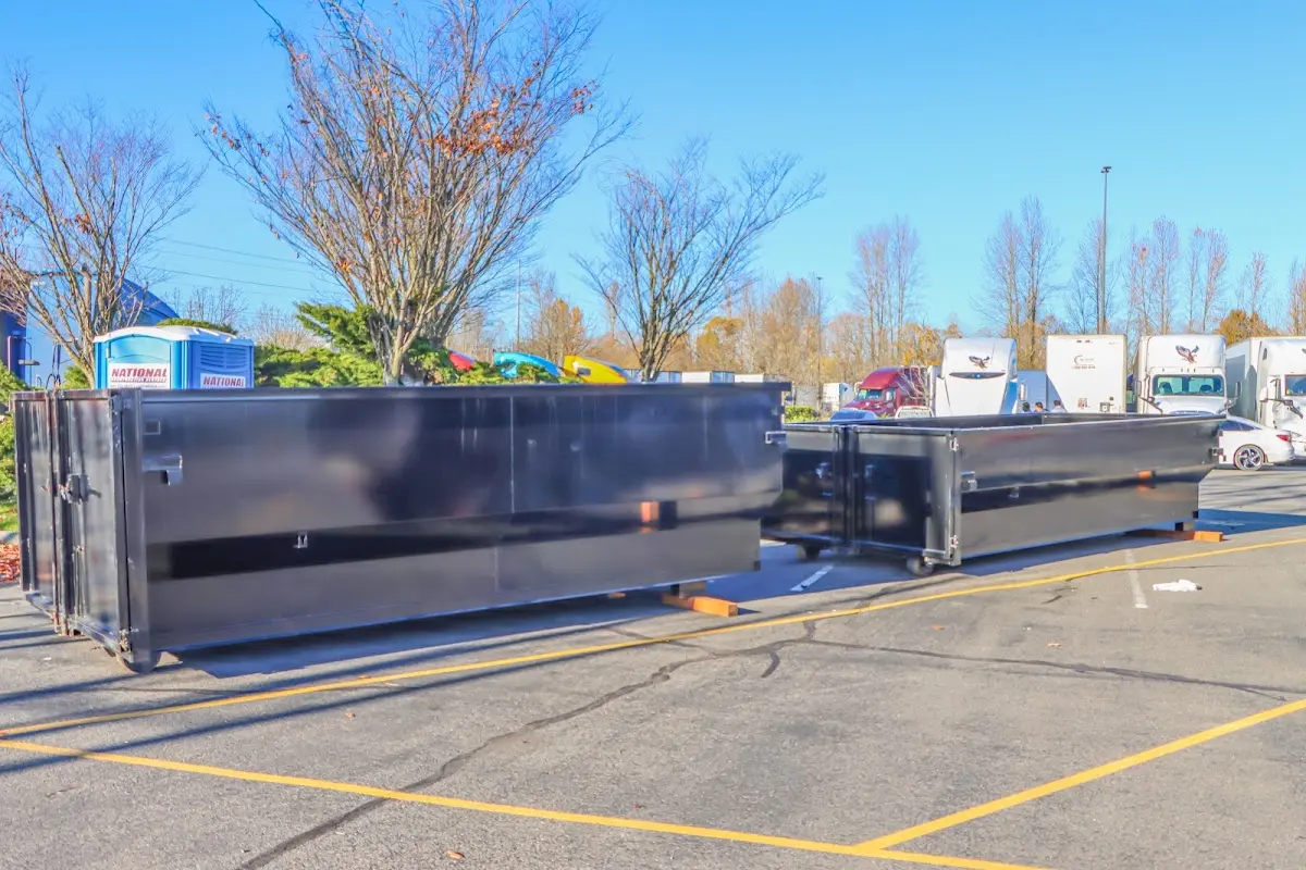 Professional dumpster rental service with roll-off container on residential driveway in South River